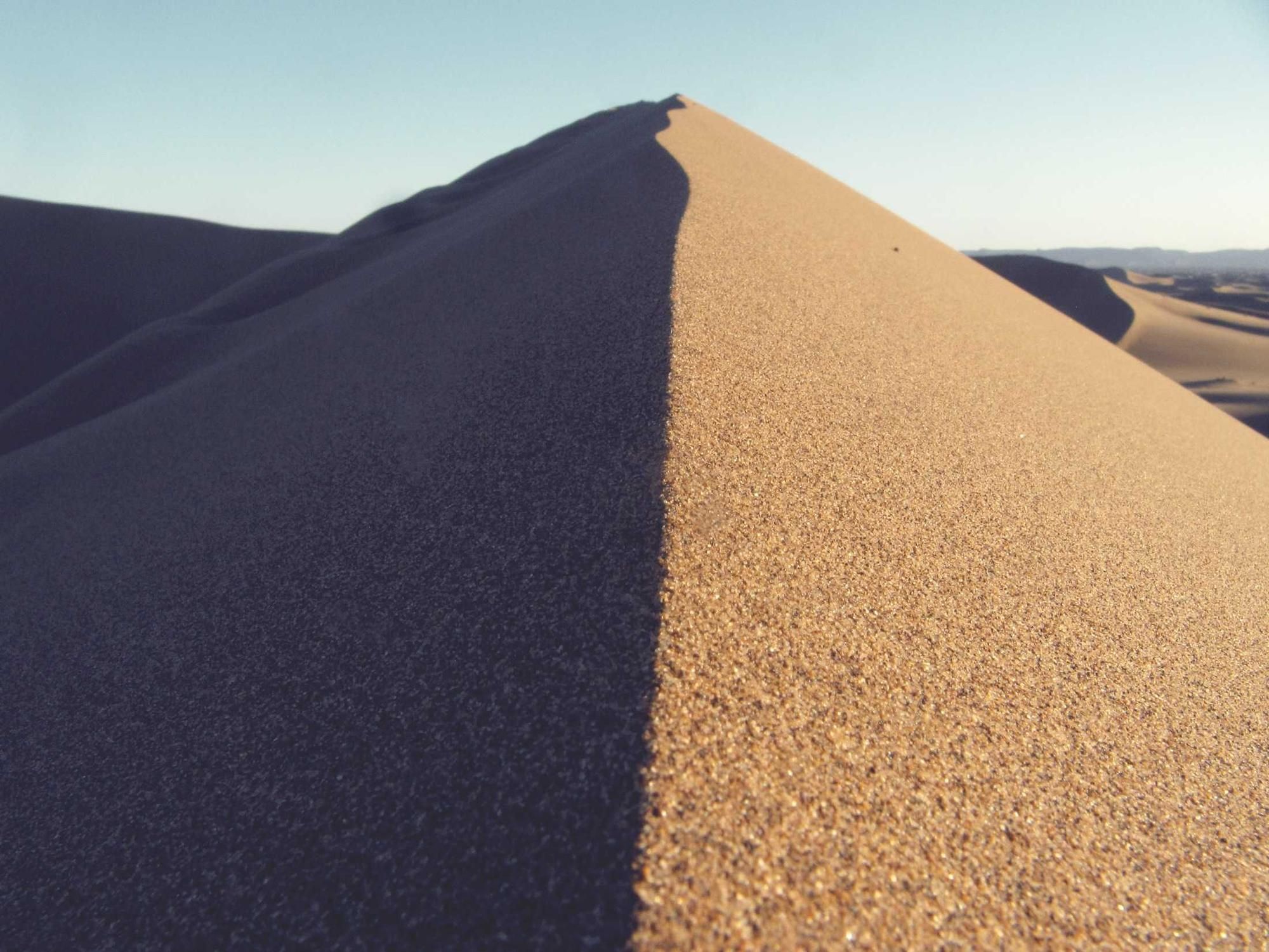 A sand dune ridge split into light and shadow