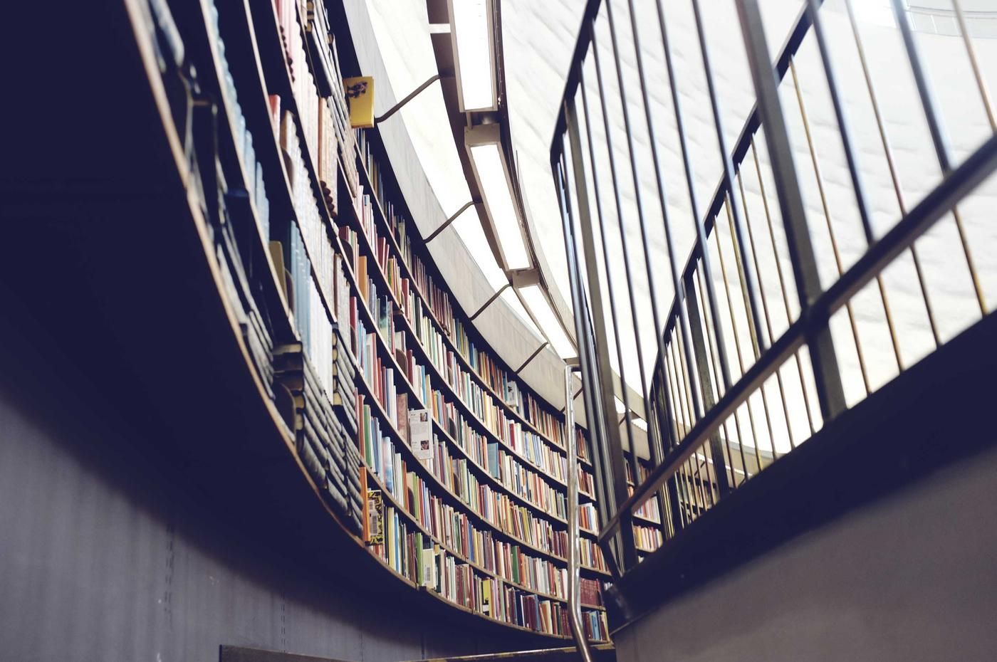 Curved library shelves under a glass roof